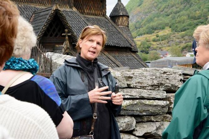 ATTRAKSJON: Tanna Gjeraker, dagleg leiar ved Borgund stavkyrkje, medan ho guidar og fortel ei gruppe turistar om historia til kyrkja frå 1190-talet.