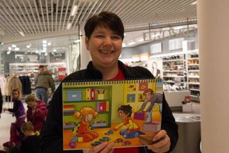 ILLUSTRASJONAR: Anne Britt Skarsbø syner fram ei av bøkene dei brukar til høgtlesing. Denne boka har bilete vendt ut mot borna medan den vaksne les.