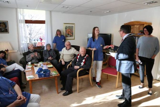 OVERREKTE SJEKK: Ordføraren overrekker ein sjekk på 20 000 kroner til Mette Kleiva. Pengane skal nyttast til sansehagen som er planlagt utanfor sjukeheimen.