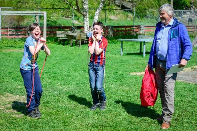 HOPPANDE GLADE: Rektor Torfinn Grøttebø avslører kven som er vinnarane av hoppetaukonkurransen. Ingvar og Sigve Rudningen Opdal og resten av elevane visste ingenting om kvifor dei var samla etter storefri.