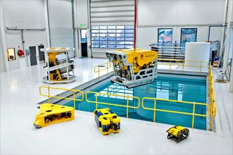 Kystdesigns undervannsroboter i ulike varianter. Til venstre på gulvet foran bassenget ligger den nye notvaskeren. De to minste robotene er observasjons-ROV'er som produseres hos Ocean Robotics i Sverige. Erik Bakkevig eier 25 prosent av bedriften.