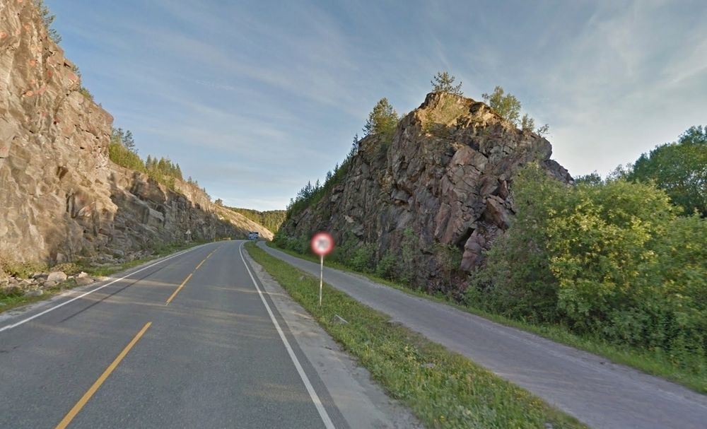 Den nye E6 skal gå tvers gjennom bergnabben til høyre. Kruse Smith er i gang med å sprenge den bort. Den som får kontrakten på tilstøtende veger, skal fordele sprengsteinen.