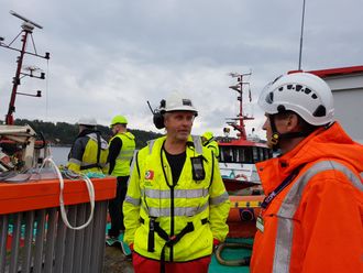 Senioringeniør Jan Willie Holbu i Kystverket (t.h.) i samtale med mannskap fra Kragerø Sjøtjeneste.Selskapet stilte med to slepebåter som la ut ogtestet lenser under Scope 2017.