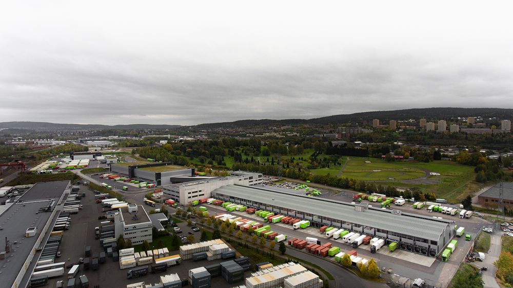73 000 kvadratmeter med logistikksenter ser slik ut fra luften. Den gamle godssentralen er til høyre på bildet, mens den nyere delen sees oppe til venstre. Legg merke til gangbroen midt på bildet som knytter delene sammen. Her passerer gående ansatte og pakker på bånd.