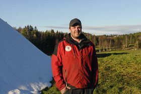 Løypebas Terje Martinsen for 10 dager siden da gresset fortsatt var grønt! Her står han ved siden av snøhaugen han hadde produsert med en annen snømaskin.