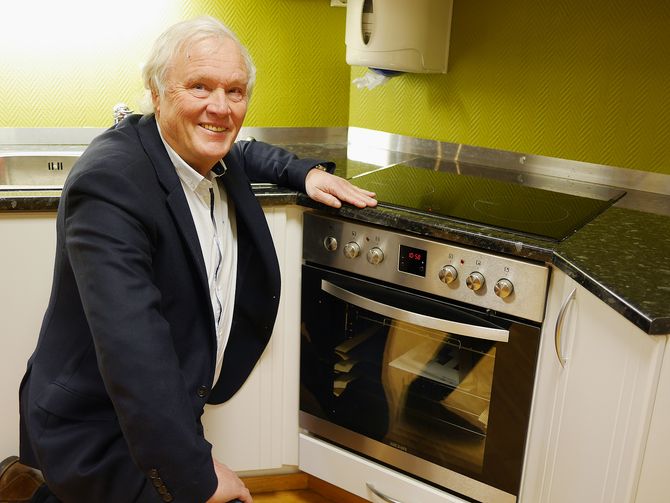 Salgs- og innkjøpssjef Terje Lind med Behas eneste innbyggingsovn, der koketoppen styres fra komfyr-betjeningen. Foto: Stian Sønsteng