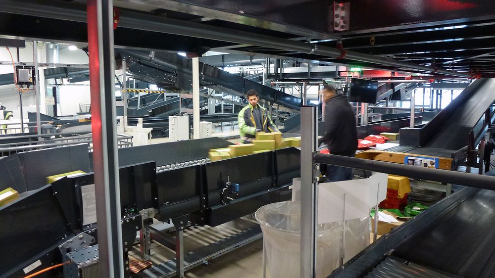 Ferske pakker singuleres og legges riktig med strekkoden opp. Tross automatisering er det fortsatt stort behov for menneskelige hender for å få posten frem.
