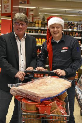 JUL TIL ALLE: Denne ribba på 13 kilo skal pryde bordet på Tårnåsen aktivitetssenter. Det er Meny Greverud som sponser all mat. og Landstormen som arrangerer. Fra venstre står Tom Westerlin og kjøpmann Øyvind Øvsthus. PS: Det blir kyllinggryte til de som ikke spiser svin!