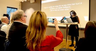 Kulturminister Linda Helleland tar bilde når assisterende generalsekretær Reidun Nybø i Norsk Redaktørforening snakker.