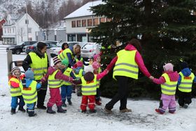 SÅ GÅR VI RUNDT...: Ikledde vinterdressar og refleksvestar gjekk borna og dei vaksne frå barnehagen i lag rundt treet tysdag morgon.
