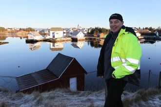 Kjell Samnøy foran en «signaturjobb» i bygda, muren foran det flotte huset på nedsiden.