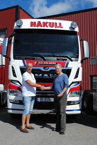 Steinar Solberg, eier og daglig leder i H. K. Solberg Transport AS (til høyre), mottar seks nye MAN TGX 26.580 fra Johannes Erlandsen, salgskonsulent for MAN Truck & Bus Norge AS i Kristiansand.