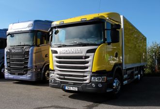 Scania Hybrid G 320 fotografert ved siden av en flunkende ny S 730. Scania-designerne har klart kunststykket å få den nye bilen til ikke å se veldig futurisk ut, samtidig som hybriden fra den gamle serien ikke ser gammel ut.