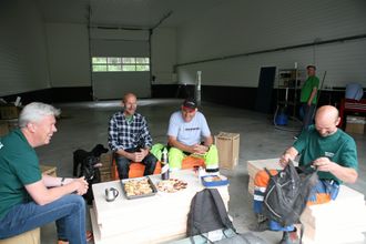 VERKSTED: Hjemmesmurt formiddagsmat inntas i døråpningen på det nye verkstedet, fra venstre Jon Ølstad (Volvo Maskin), Hans Gomnæs, Tor Bråthen og Ole Petter Gomnæs.