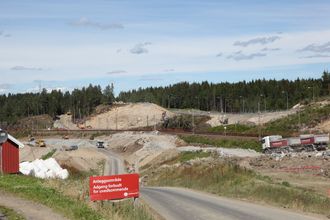 Ut av den lysebrune bergveggen midt i bildet skal TBM-ene komme etter planen.