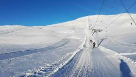 Bilete teken frå skiheis. Utsikt mot toppen som er dekka i snø.