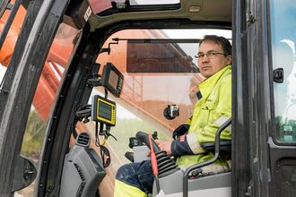 Lars Pedersen har en skjerm for GPS-en til boretårnet og en skjerm for gravesystemet.