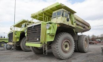 De to grønne tipptruckene hviler seg etter dagens innsats.