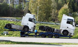 Tralla med de to trekkbilene ble parkert ved fornøyelsesparken Tusenfryd der E6 og E18 krysser hverandre. De tilhørende sjåførene følger bilene sine uansett om de kjører selv eller bilene er lasset.