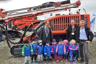 Avduket Dino-rigg er synliggjort for «all verden» på anleggsmessen med barnehagebarna i front. Det var stor glede hos Sandvik-selger Knut Nybø (t. h.), messegeneral og regionsjef Paul Olaf Baraas i MEF og varaordfører Svein Olsen over å få en verdenslansering ved messeåpningen.