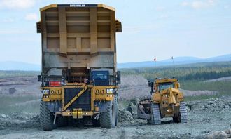 Et lass med gråstein avleveres. Den lille dozeren ved siden av tipptrucken er en Cat D10!