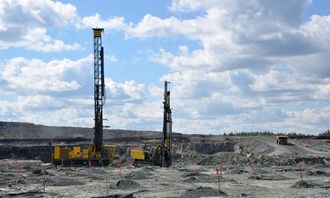 En Pit Viper 271 rotasjonsboreriggog en FlexiROC D65 senkborerigg, begge fra Atlas Copco, i aksjon i dagbruddet.