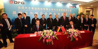 Schmitz Cargobulls toppsjef Ulrich Schümer (til venstre foran) og Zhu Fushou, generaldirektør i Dongfeng og høyt oppe i kommunistpartiet, undertegner avtalen om Joint Venture for produksjon av semitrailere. Bakteppet er styremedlemmer i de to selskapene.