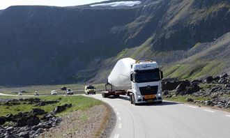 Bakre del av konvoien kjører gjennom den storslåtte naturen ved Berlevåg med turister og lokalbefolkning på hjul. Trekkbilen med vingen er en Mercedes-Benz 510 hk, 6x2 med standard girkasse.