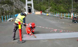 Siste finpuss på malingen. Sittende på huk kontrollingeniør Ketil Engen, Statens vegvesen.