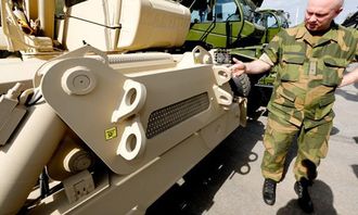 Teknisk koordinator Kjetil Oldebråten viser noe av det Forsvaret har bedt om som skiller disse fra standard Manitou-maskiner, ekstra tilkoblingsøyne flere steder på maskinene.