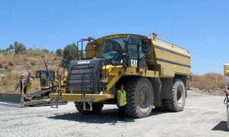 På et Cat tipptruckchassis er det bygd en spesialutstyrt vanningsbil med 13.000 liters tank levert av påbyggeren MECA. Vannet er høyst nødvendig for å holde støvplagen i sjakk på det tørre ørkenaktige test- og demoområdet.