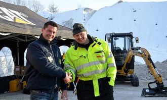 Første maskinsalget på konvoien, Cat-selger Idar Gilje (t.h.) gratulerer Kristen Holand i T. Holand Maskin med en Cat 303.5 ECR.