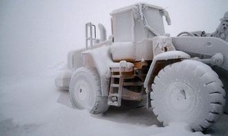 Snøstormen har pakket inn en Volvo L150 hjullaster.