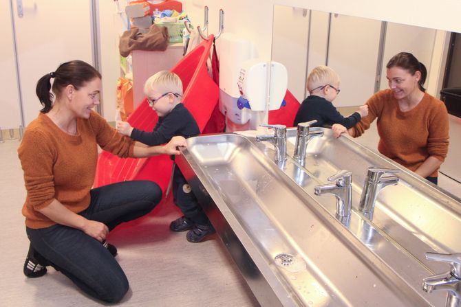 Pedagogisk leder i Læringsverkstedet Trålveien barnehage i Bodø, Marita Kolin, er Troys (3) egen ressursperson. – Vi er som et gammel ektepar, ler hun og får hjelp til å vaske seg på armene av treåringen.