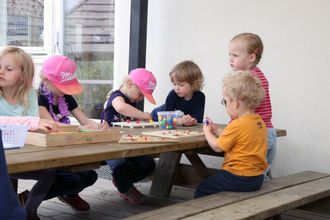 De voksne tar gjerne perler, tegnesaker og puslespill med ut, slik at barna har noe gøy å holde på med i skyggen under hageteltet.