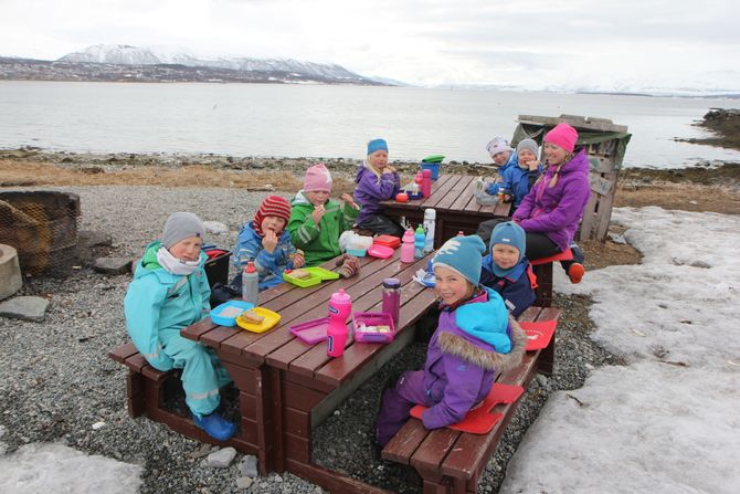 Ungene i Tusseladden friluftsbarnehage er enige om at maten smaker best ute. Her nyter de formiddagsmaten sammen med Lisa Strøm Brovold.