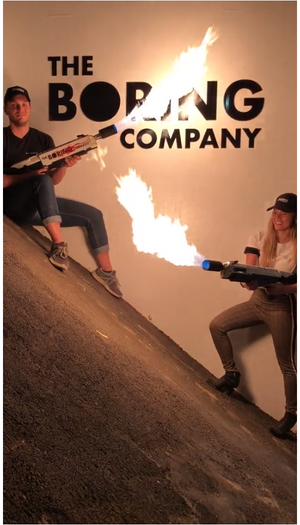 To personer holder hver sin flammekaster foran logoen til The Boring Company.