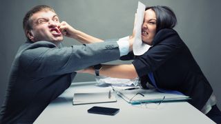 Ung mann og kvinne slåss begynner å slåss på et møterom.