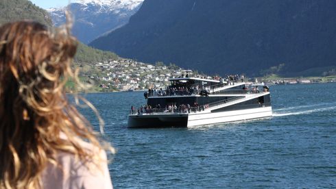 Future of the Fjords, som er 100 prosent elektrisk, møter hybridfartøyet Vision of the Fjords like ved Flåm i Aurlandsfjorden. Begge turistbåtene er bygget av Brædrene Aa i karbonfiber for The Fjords.