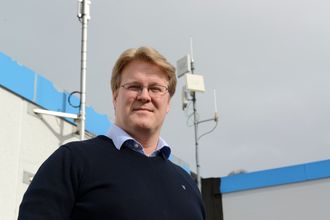 Krevende it-drift: Konstituert IT-sjef Bent Iversen ved antennen som kommuniserer med det nærmeste anlegget, rett over fjorden fra hovedkvarteret.