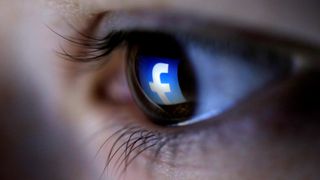 Illustrasjon hvor en rettvendt Facebook-logo reflekteres i øyet til en person.