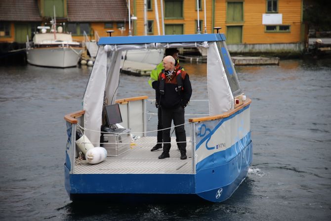 Førsteamanuensis Egil Eide og student Tobias Torben (gul jakke) tar en piruett med Milliampere i Smedasundet i Haugesund etter demonstrasjonen av autonomi-fergen for Sjøfartsdirektoratet.