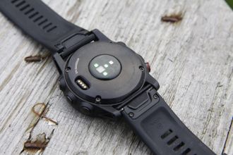 Fenix 5X Plus har en optisk pulsmåler på undersiden. Til venstre ser du ladekontakten.