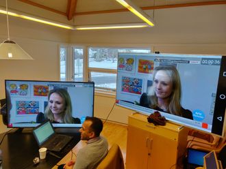 NRK har startet prøvesendinger med TV over 4G/5G-nettet. Fra pressekonferanse. To store TV-er i bakgrunnen.