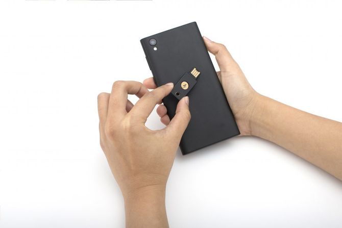 YubiKey 5 NFC, en sikkerhetsnøkkel fra Yubico, brukes til autentisering på en Android-mobil.