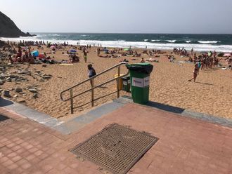 Fiberkabelen kommer i land på denne stranden i Baskerland. Det står «fiberoptisk kabel» på lokket i forkant av bildet.