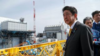 Foto av mann foran atomkraftverk. Japans statsminister.