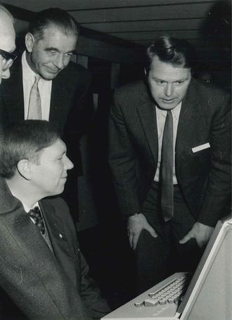 Fra innvielsen av UNIVAC 1110-maskinen til Universitetet i Bergen i 1973. Sittende ved terminalen Magne Lerheim, stående bak: Ernst Selmer og Kåre Bjørnenak.