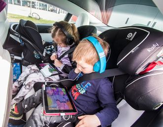 Tre barn i baksetet i Model 3.