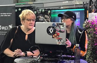 Trine Skei Grande og en kvinnelig TG-deltaker ser på en laptop-skjerm.